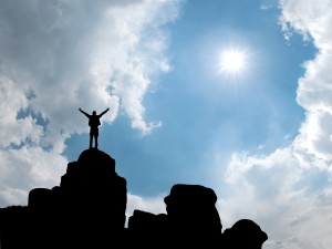 Happy man standing at mountain top